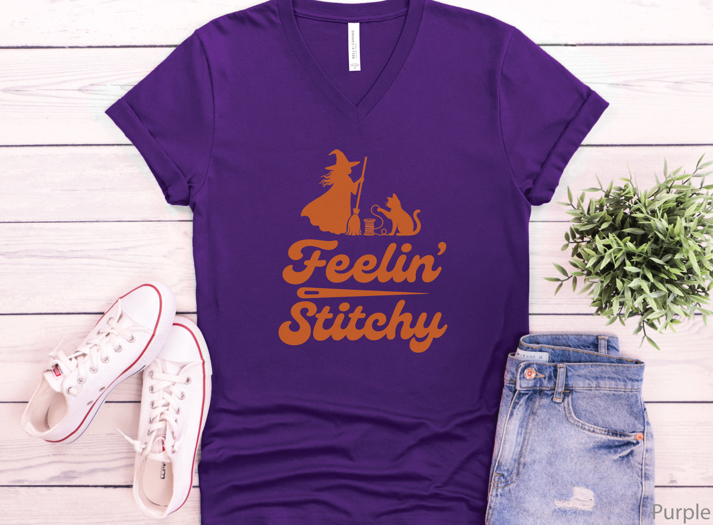 Feelin’ Stitchy Halloween t-shirt featuring a silhouette of a witch with a black cat and spool of thread, designed for sewists, quilters, and stitch witches.
