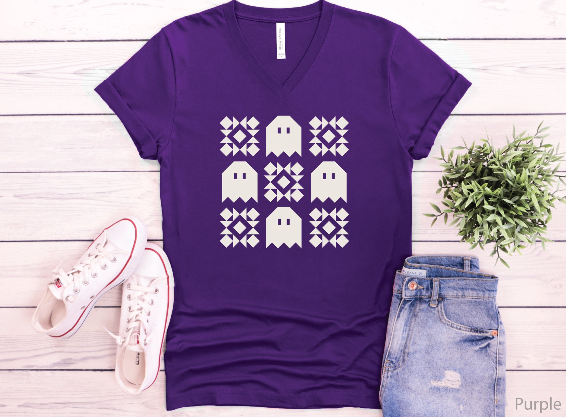 Soft Bella + Canva V-neck Halloween quilting t-shirt featuring a cream grid design with four spooky ghosts and five geometric quilt blocks. A customer favorite!