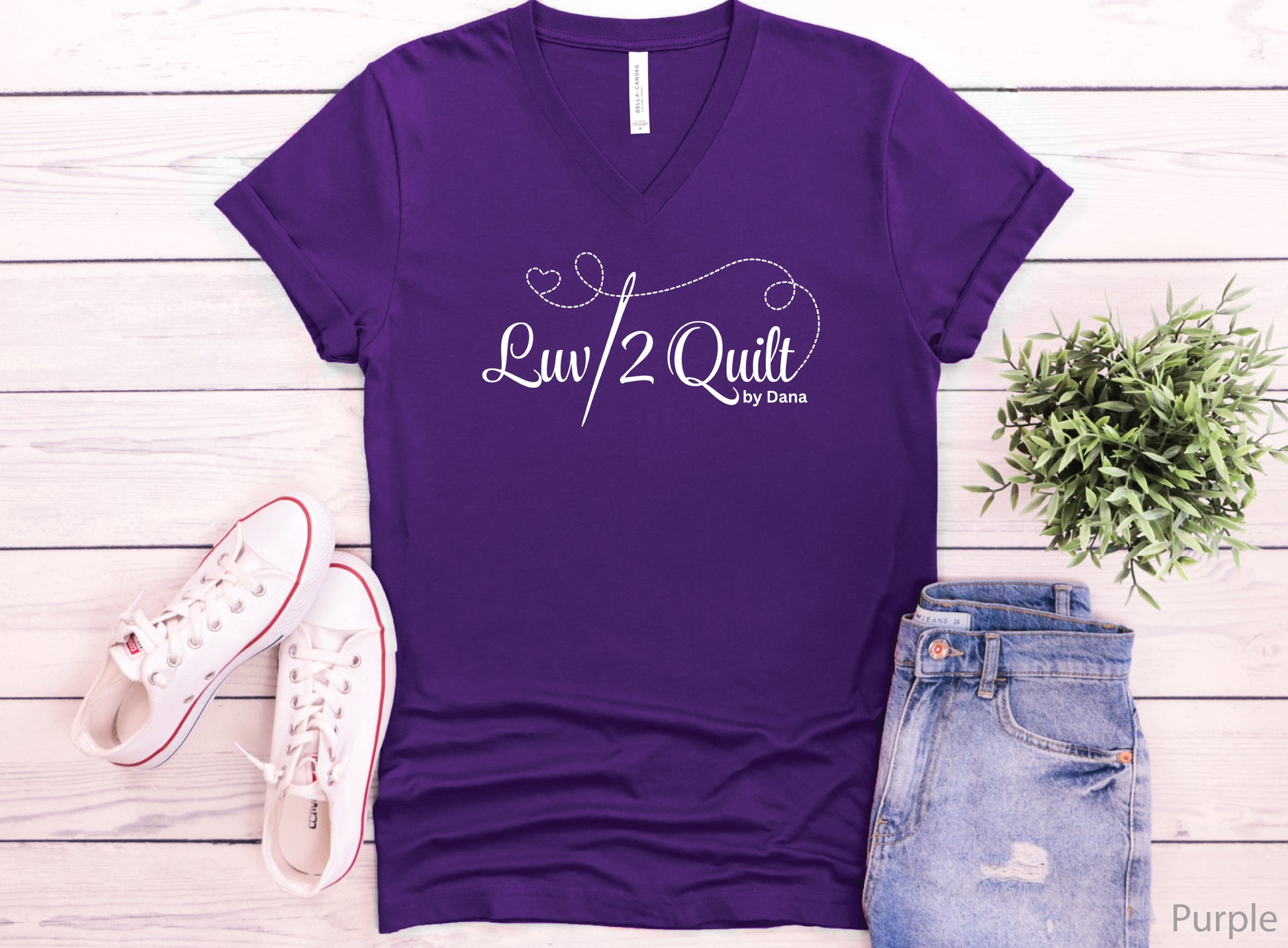 Official Luv2Quilt by Dana quilting-themed t-shirt featuring the Luv2Quilt logo with a sewing needle and stitched heart design, perfect for quilt classes, retreats, and everyday wear.