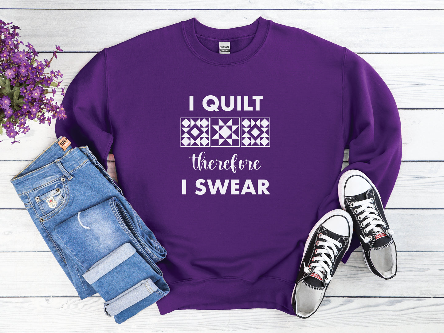 A cozy quilting sweatshirt from Bee Inspired Tees featuring the phrase “I Quilt, Therefore I Swear,” a funny and relatable gift for quilters who love to sew, laugh, and stay warm while stitching.
