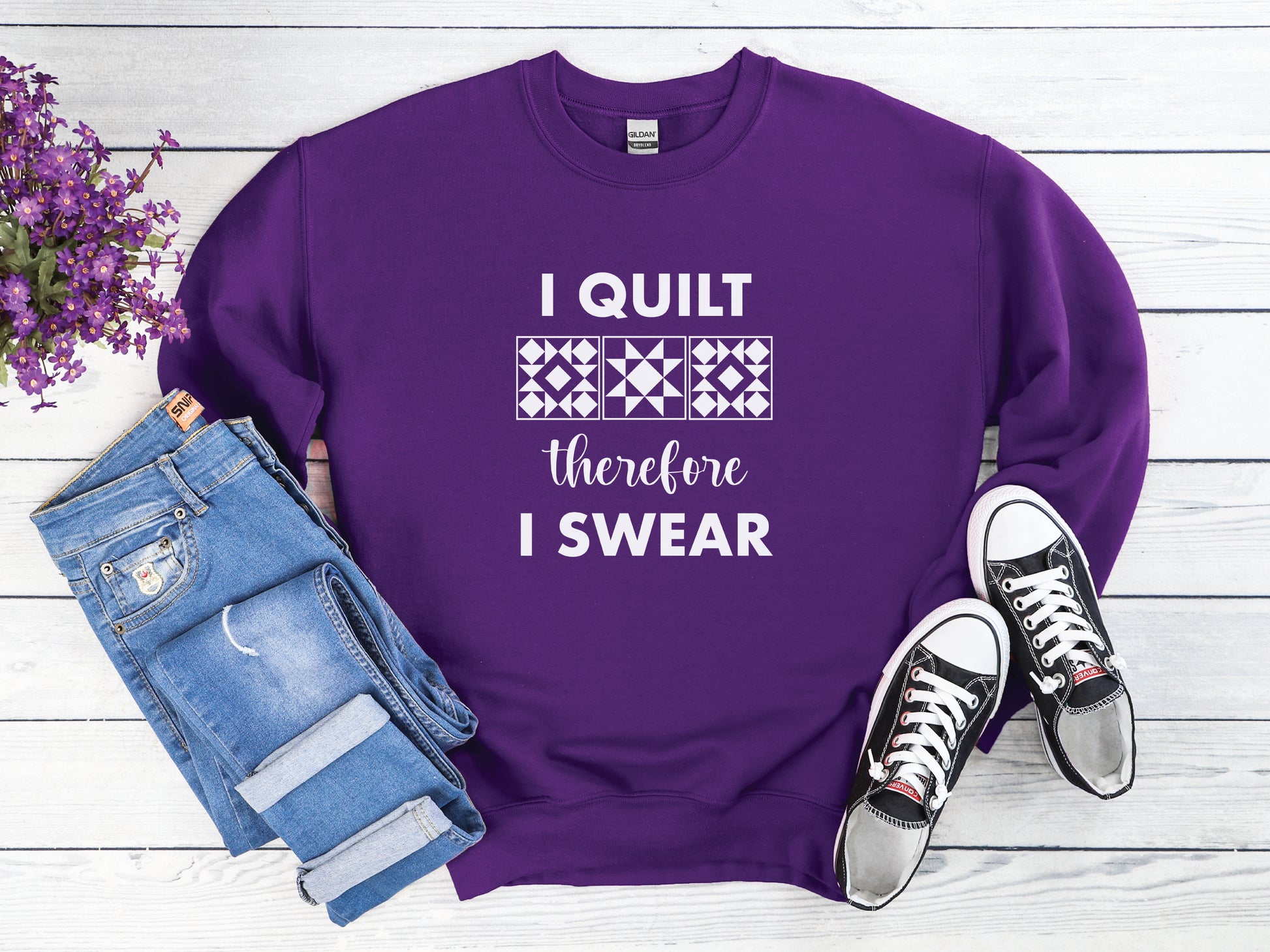 A cozy quilting sweatshirt from Bee Inspired Tees featuring the phrase “I Quilt, Therefore I Swear,” a funny and relatable gift for quilters who love to sew, laugh, and stay warm while stitching.