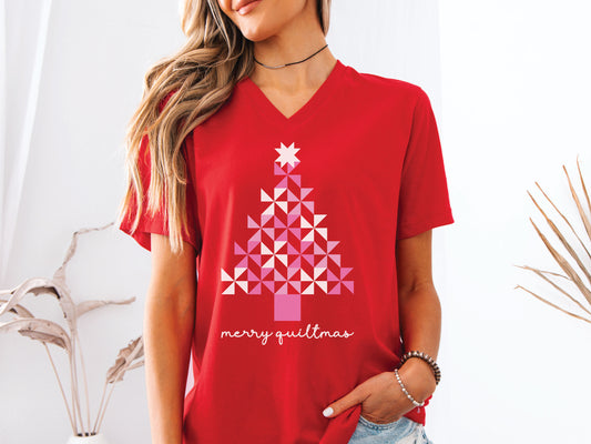 A Christmas tree made of pink pinwheel quilt blocks with the phrase “Merry Quiltmas,” printed on a festive V-Neck T-shirt for quilters who love handmade holiday cheer.