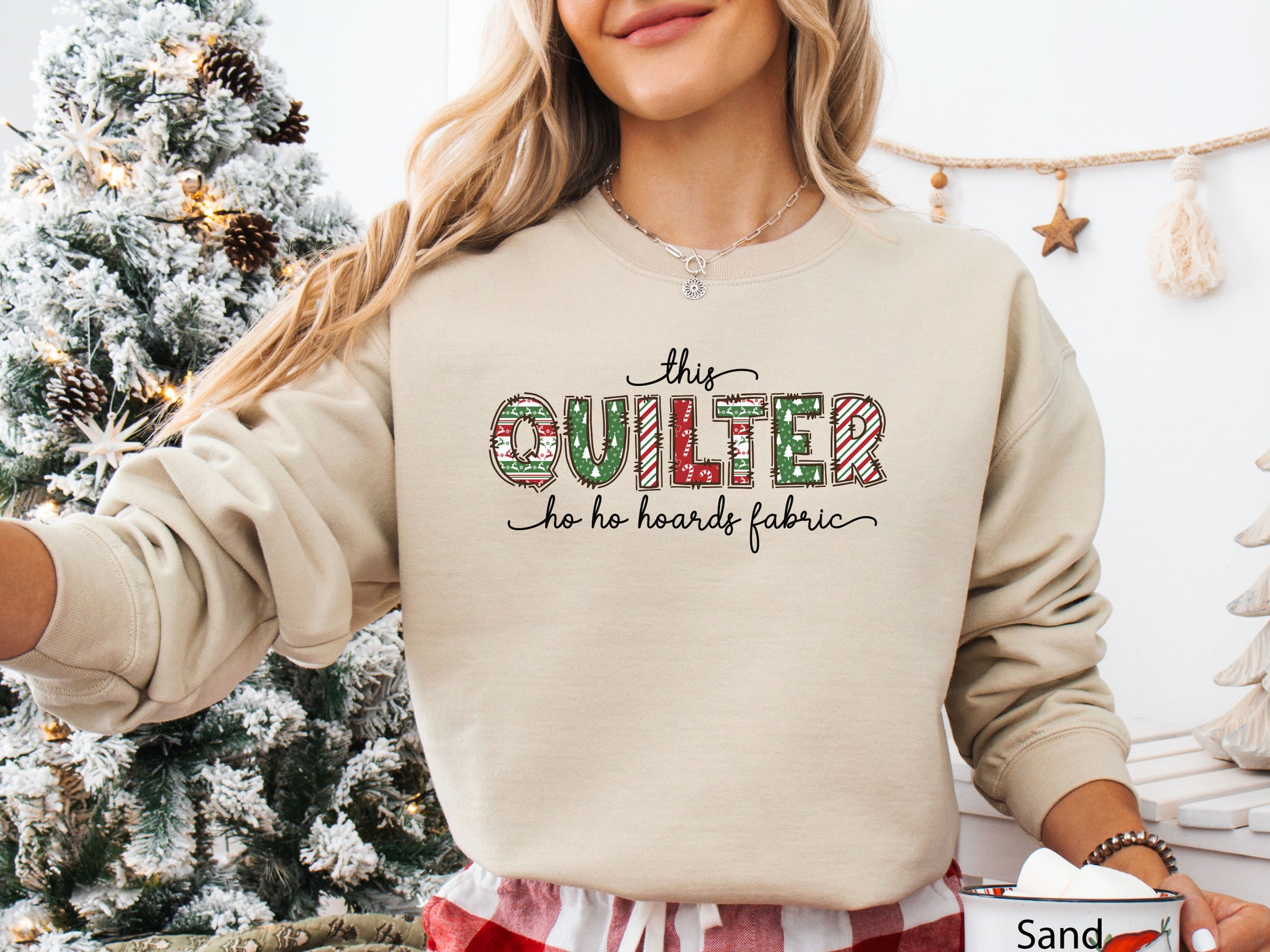 Cozy sweatshirt with playful patchwork lettering that says “This Quilter Ho Ho Hoards Fabric” — festive Christmas gift for quilters and sewing enthusiasts.