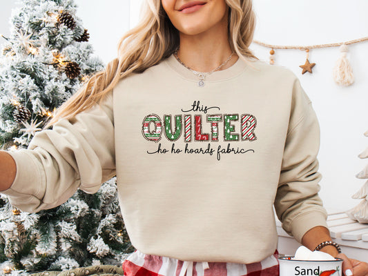 Cozy sweatshirt with playful patchwork lettering that says “This Quilter Ho Ho Hoards Fabric” — festive Christmas gift for quilters and sewing enthusiasts.