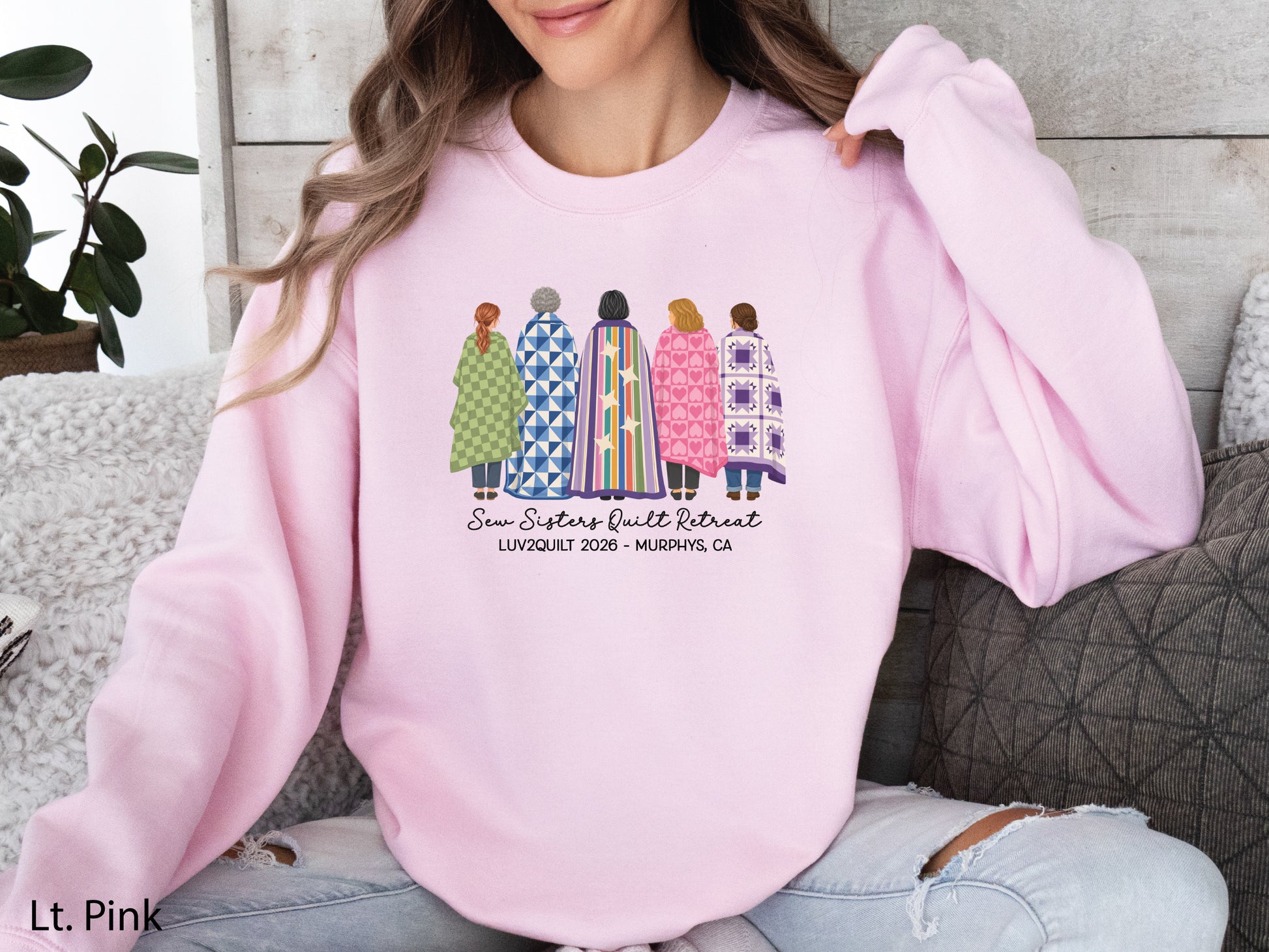 Sew Sisters Quilt Retreat shirt design featuring five women wrapped in colorful green, blue, striped, pink heart, and purple quilts with LUV2QUILT 2026 – Murphys, CA text.