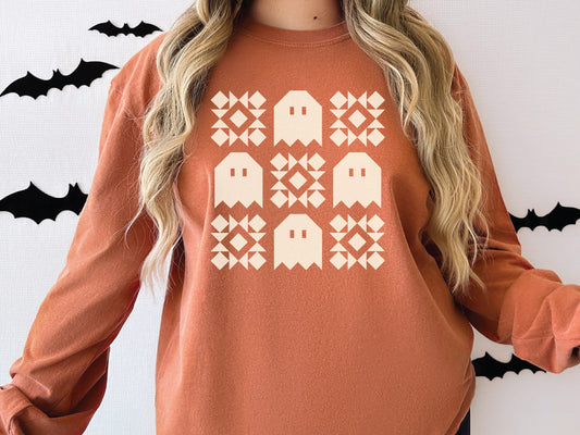 Halloween quilt long sleeve Comfort Colors t-shirt in Yam orange with spooky ghost quilt blocks—perfect fall gift for quilters.