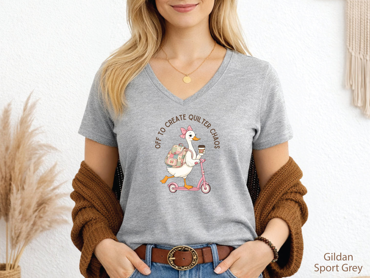 Funny quilting t-shirt featuring a goose riding a pink scooter with coffee and a patchwork backpack, paired with the saying “Off To Create Quilter Chaos.” Perfect for quilters, sewists, quilt retreats, and fabric lovers.