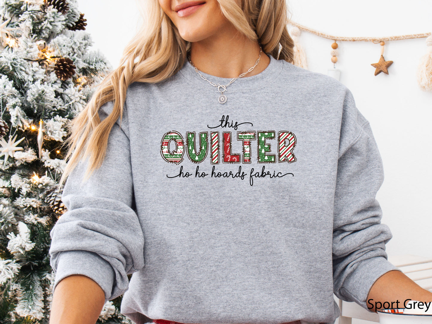 Cozy sweatshirt with playful patchwork lettering that says “This Quilter Ho Ho Hoards Fabric” — festive Christmas gift for quilters and sewing enthusiasts.