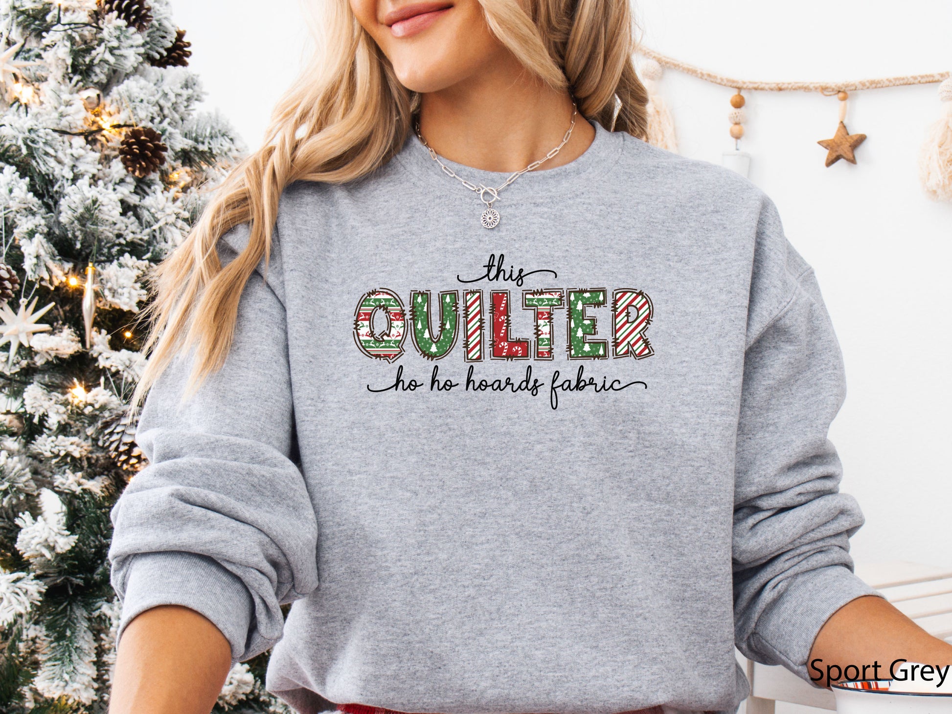 Cozy sweatshirt with playful patchwork lettering that says “This Quilter Ho Ho Hoards Fabric” — festive Christmas gift for quilters and sewing enthusiasts.
