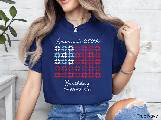 Patriotic quilting t-shirt featuring red, white, and blue quilt blocks with “Quiltin’ USA” design celebrating America’s 250th Birthday, printed on a Comfort Colors shirt.