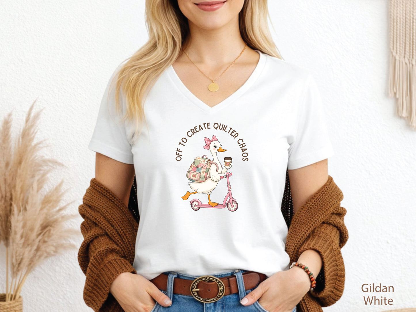 Funny quilting t-shirt featuring a goose riding a pink scooter with coffee and a patchwork backpack, paired with the saying “Off To Create Quilter Chaos.” Perfect for quilters, sewists, quilt retreats, and fabric lovers.