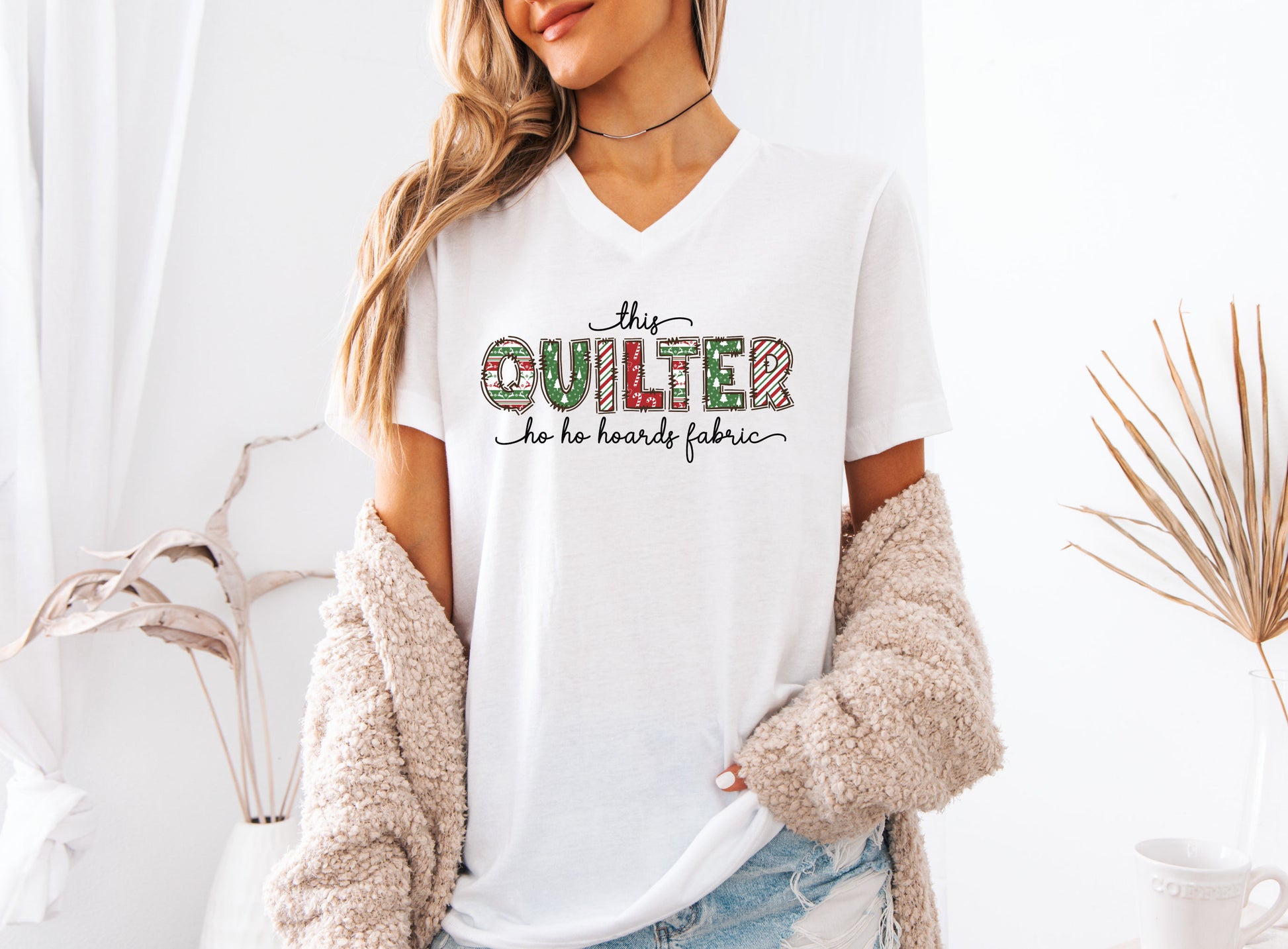 This Quilter Ho Ho Hoards Fabric V-Neck t-shirt with red and green patchwork lettering, a funny Christmas shirt for quilters who love fabric, sewing, and holiday cheer.