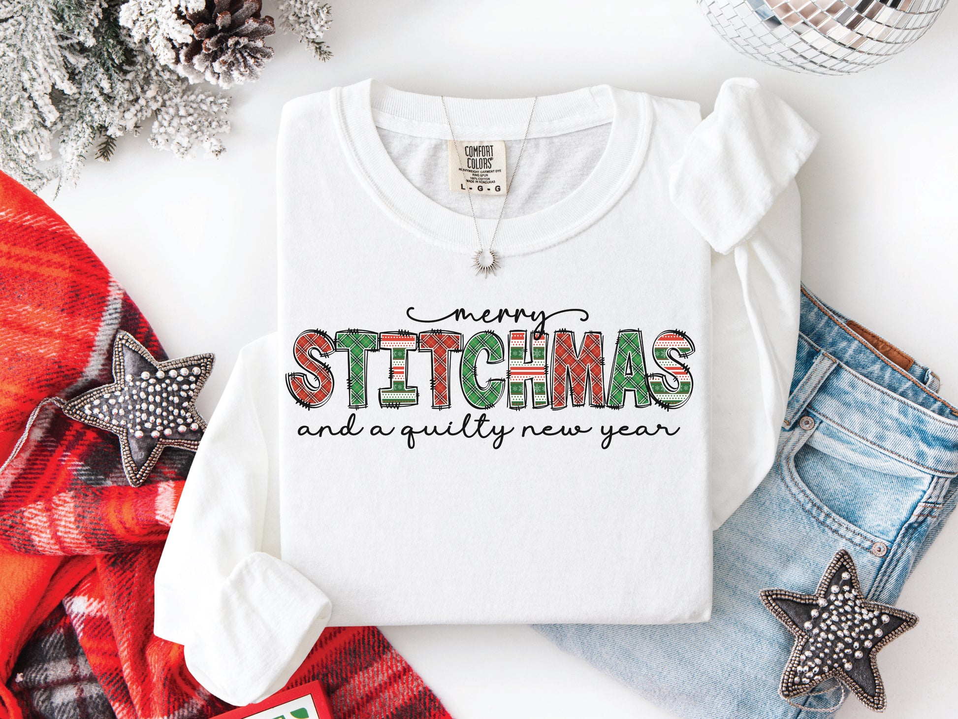 Festive Merry Stitchmas & a Quilty New Year t-shirt with red, green patchwork lettering—perfect holiday gift for quilters and sewists.