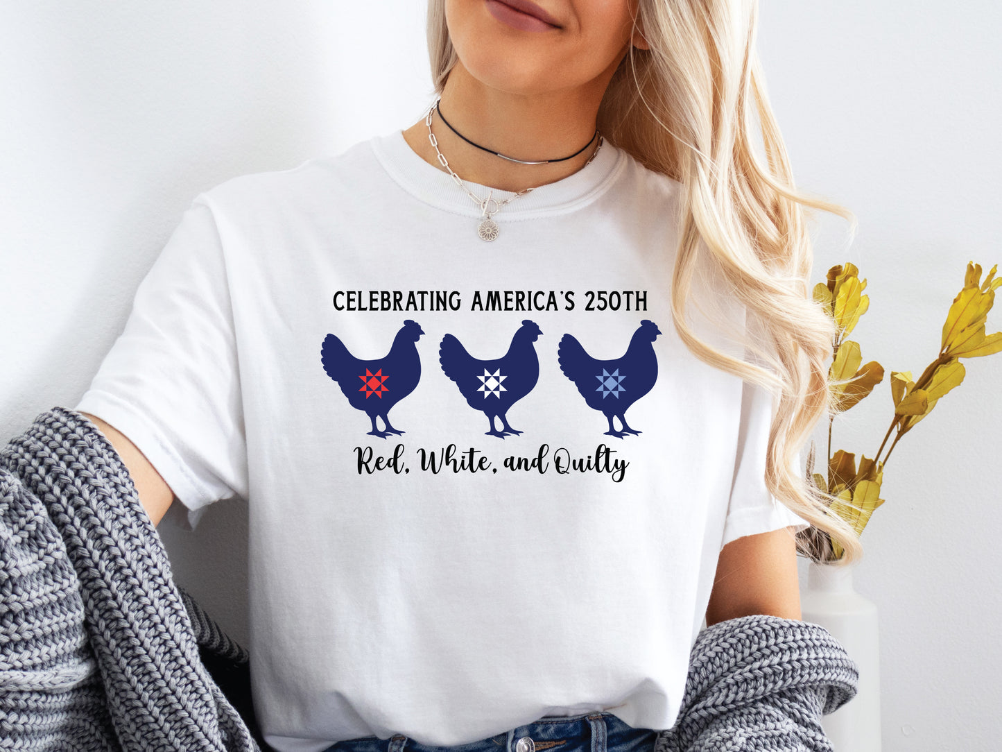 Patriotic quilting t-shirt with three chickens featuring red, white, and blue quilt star blocks and the phrase “Celebrating America’s 250th – Red, White, and Quilty.”