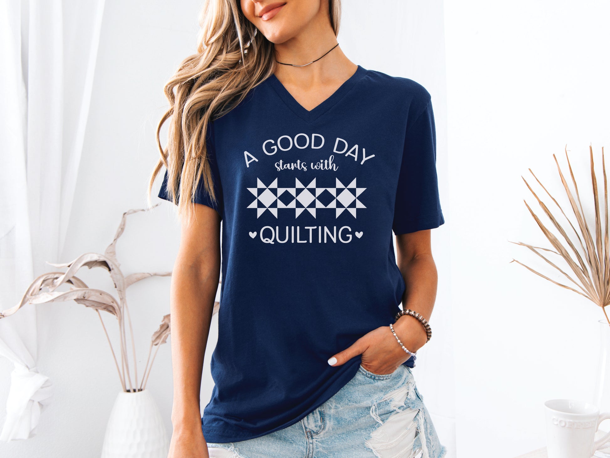 A Good Day Starts With Quilting” T-shirt on a soft navy V-neck — a fun gift for sewing and quilting lovers, celebrating every stitch, even with a seam ripper.