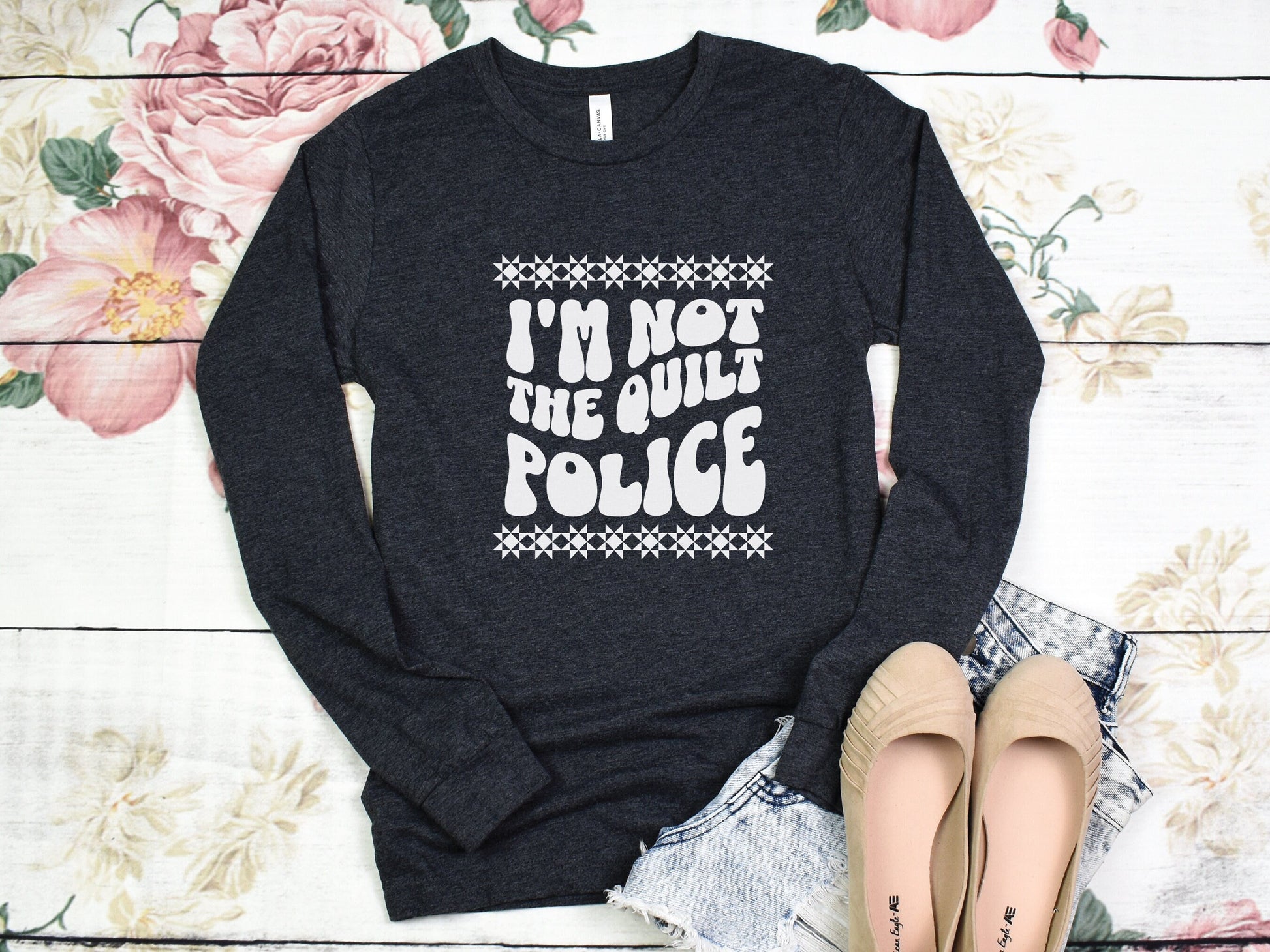 Looking for a funny quilting shirt for yourself or a quilting friend? Quilters know all too well about the Quilt Police (those pesky undercover sassy quilters). This quilt shirt has retro wavy Quilt Police text and a fun quilt block boarder.