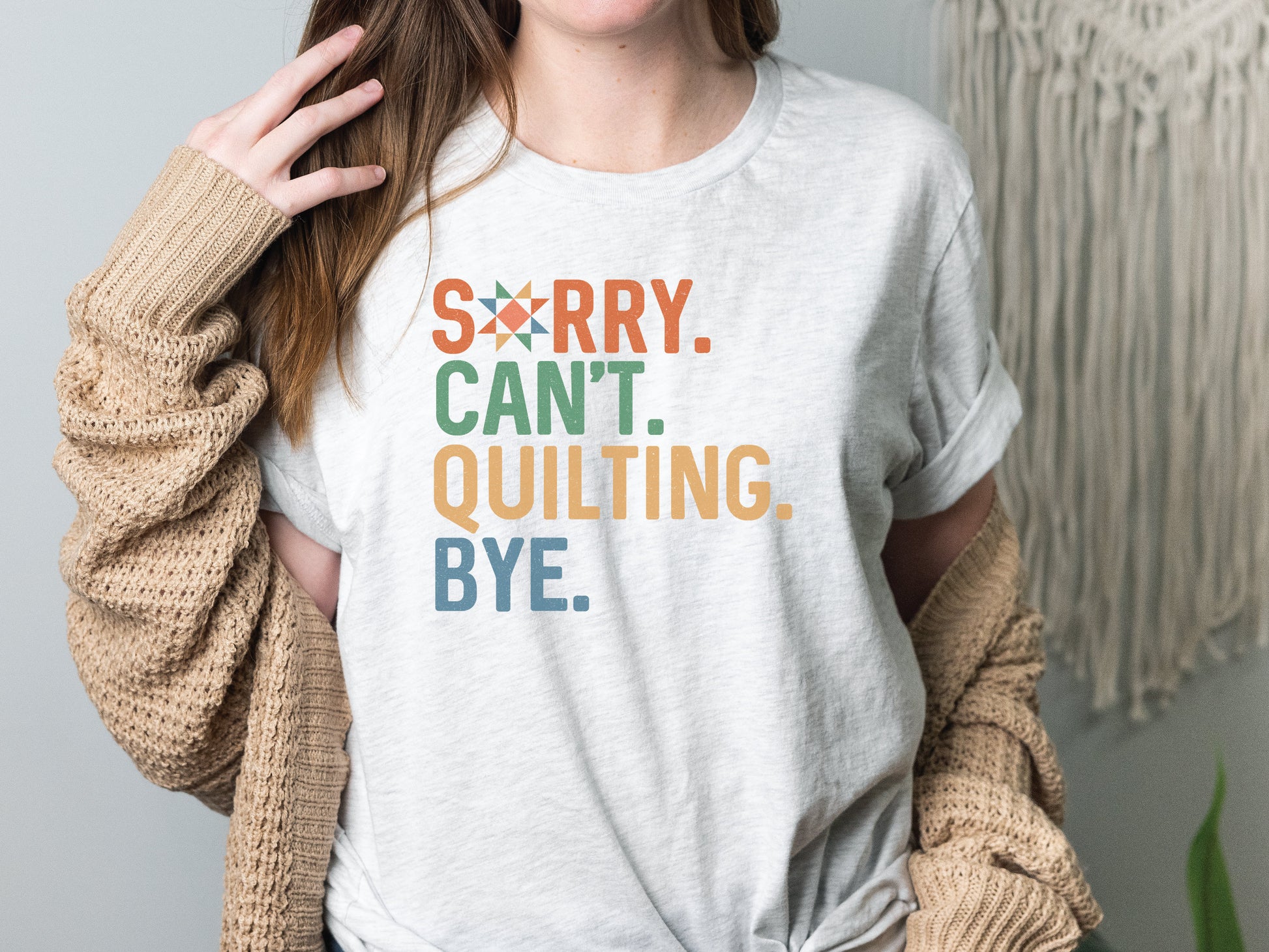 The (distressed style) text on this ladies t-shirt reads Sorry Cant Quilting Bye. Each word has a colorful color text (Orange, Green, Yellow and Blue). Quilt star in the O in Sorry.