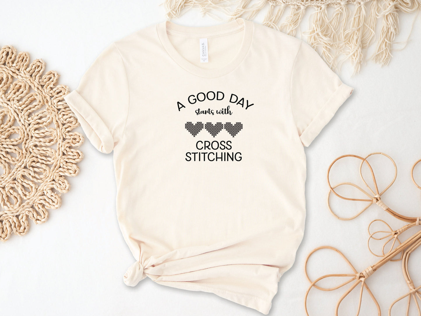 A Good Day Starts With Cross Stitching shirt, with 3 hearts printed on a natural colored shirt.