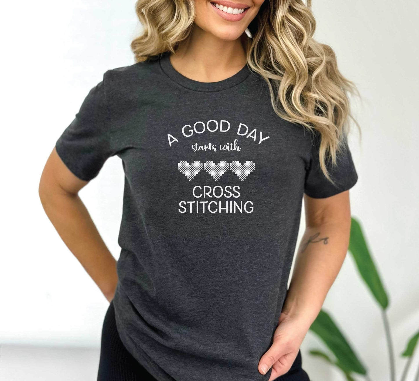 A Good Day Starts With Cross Stitching shirt, with 3 hearts printed on a dark grey shirt.