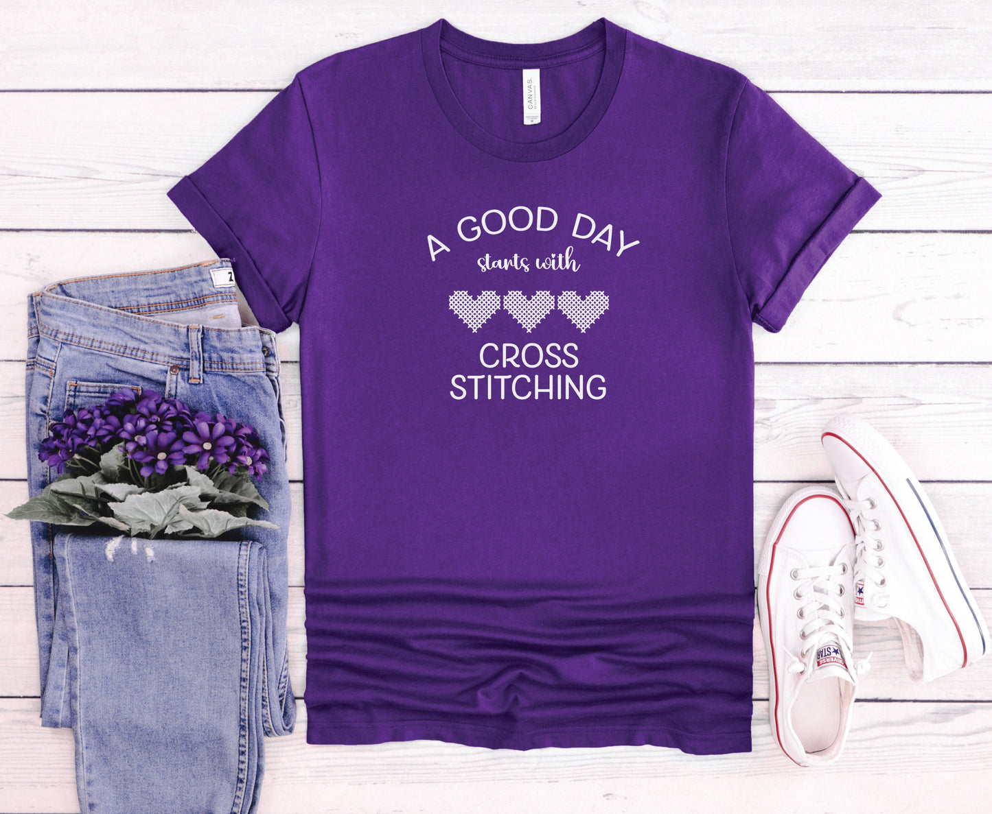A Good Day Starts With Cross Stitching shirt, with 3 hearts printed on a purple shirt.